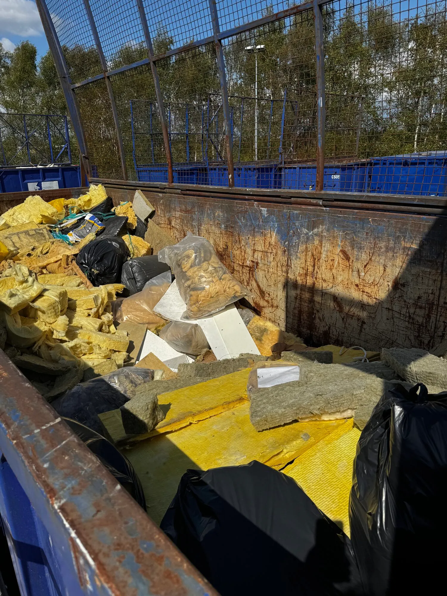 Container med isolering och byggavfall — sorterat separat